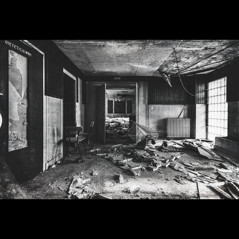 Abandonned sanatorium, b&w photo of  rooms with chairs , all is broken inside