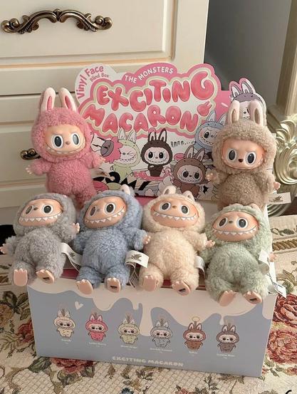 A photo of a decorated cardboard box, with 6 little Labubu Monster dolls.