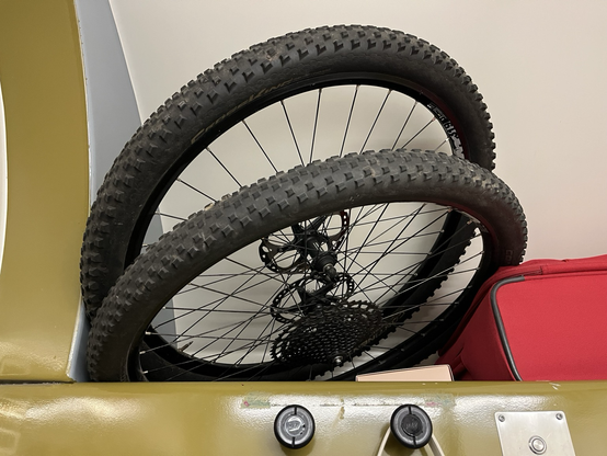 Two bike wheelers on an overhead rack of a sleeper cabin