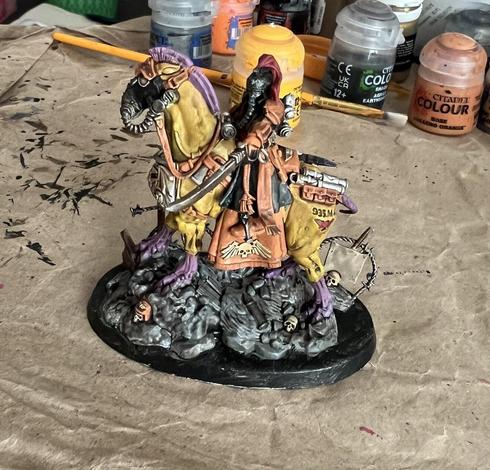 Warhammer 40K Miniature

Krieg Lord Marshall. Black uniform with orange gloves and boots, riding horse like creature with yellow fur and purple mane. Red hair coming out of top of helmet. 

Sword drawn pointing toward camera.