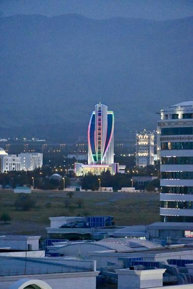 A modern building at twilight, illuminated by multicoloured lights