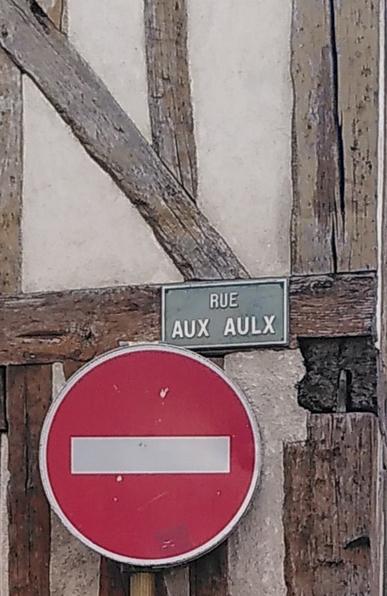 Panneau de la rue aux Aulx (Provins) au-dessus d'un panneau "sens interdit", sur une maison à pans de bois