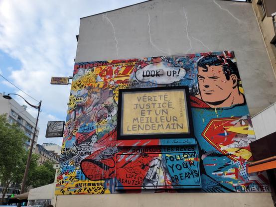 Fresque murale à Paris. "Vérité, justice et un meilleur lendemain". "Look up", "Follow your dreams" et autres inscriptions sur un mur coloré et illustré avec un dessin de superman.