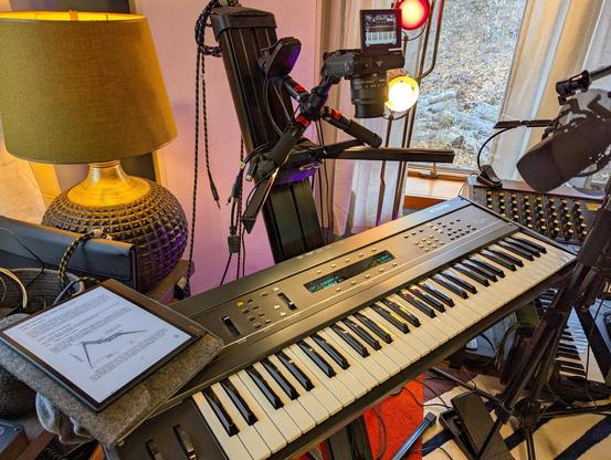 An Ensoniq ESQ-1 keyboard sits under lights and camera, ready for filming.