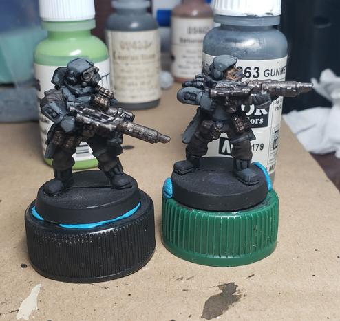 Pair of old heavily armored infantry minis in grey and brown. The one on the left has a full mask.