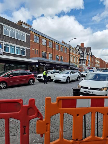 A Tesler car illegally parked in the middle of Northampton town centre's main High Street,  being ticketed.