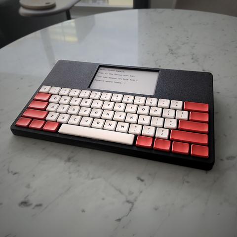 Photography of a small keyboard with a little screen directly attached to it.
