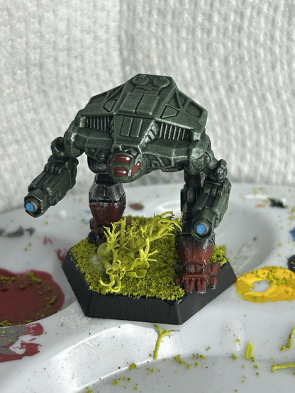 a Pouncer mech, green torso with red splashed on feet, astride a windswept tree, with some glue drying
