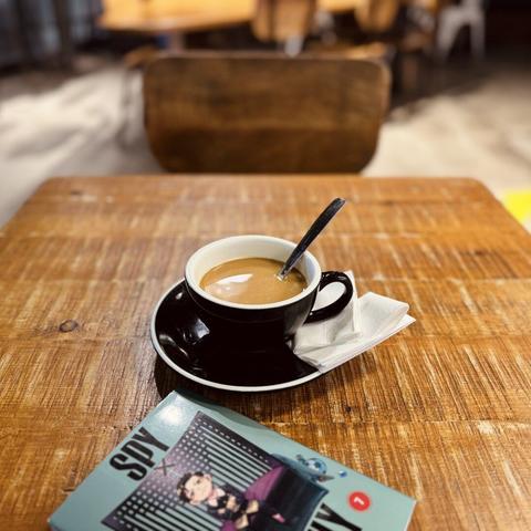 Café súper rico con leche de avena fría y el tomo 7 del manga Spy x Family