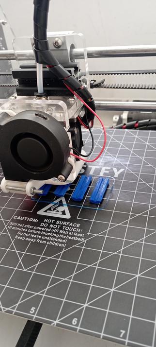 An old heavily modified Prusa i3 clone 3D printer in the middle of a print job.