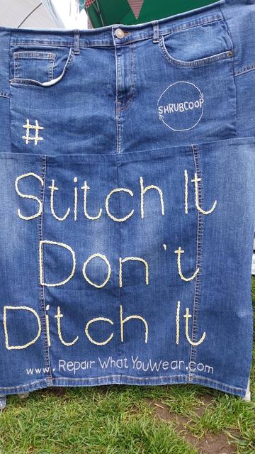 a denim banner made from old jeans that reads "Stitch It Don't Ditch It"