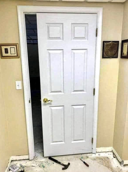 a white door inside a house but it's not wide enough to fill the door frame.