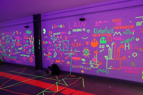 UV tape wall with lots of tape art on it. Would be a book to describe all of them, sry.