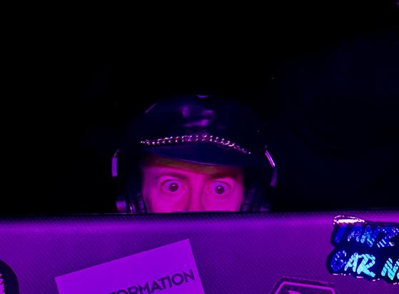 It's the eyes. DJ peering over a laptop lid during a club night.