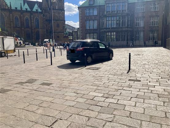 PKW parkt hinter Pollern auf Gehweg