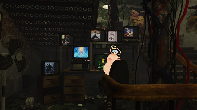 View of a desk under stairs with a lot of screens displaying various old movie posters. An avatar is sitted in front of those screens