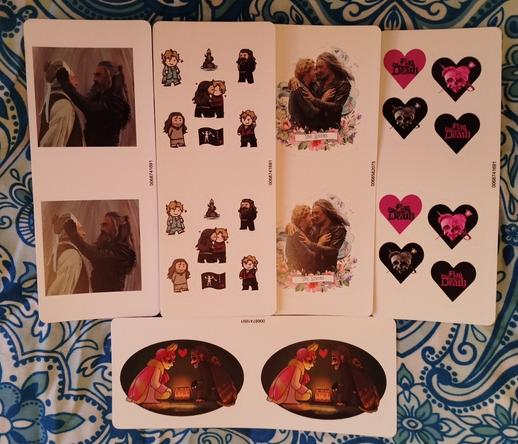 Five sets of stickers: A painting of that official photo where Ed lifts Stede's blindfold. A group of chibi Gentlebeard stickers. A "the lovers" sticker, with Stede and Ed embracing in the beach. Four separate hearts with the season 2 logos. Mothmen Ed and Stede sitting on the floor with a candle-lit cake between them.