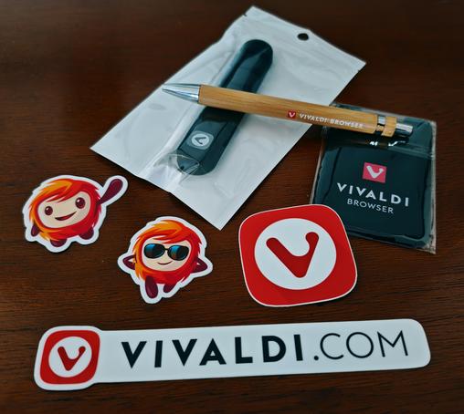 Lot de goodies Vivaldi comprenant quelques autocollants, un stylo en bois, un porte-carte et un passe-fil adhésifs.