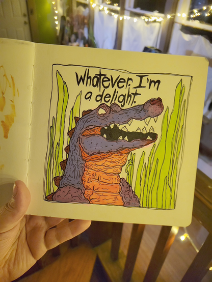 a sketchbook page of an illustrated smiling purple and orange alligator surrounded by tall green grass, with text above reading, "Whatever. I'm a delight."