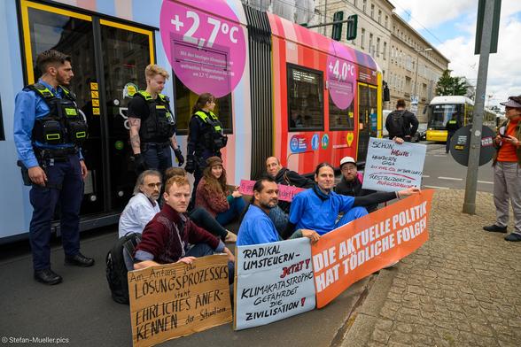 Der fast 100-tägige Hungerstreik von „Hungern, bis Ihr ehrlich seid“ wurde mit einer Straßenblockade beendet. Im Hintergrund die Klimatram von Scientists for Future, Berlin 4 Future und der Stiftung Gesunde Erde Gesunde Menschen, Invalidenpark, Berlin, 13.06.2024