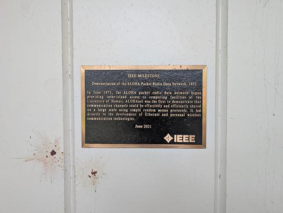 A metal IEEE plaque on a wall at U Hawaii Manoa commemorating the first ALOHA Net packet radio transmission.