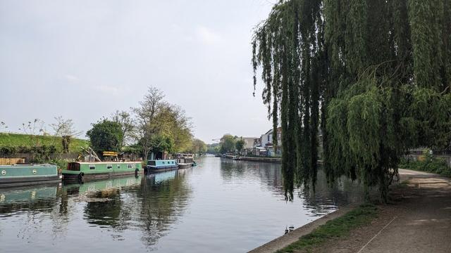 A view of the river. There are house boats moored on the far side.