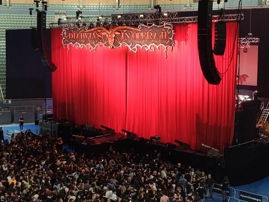 Foto del escenario del concierto de Mago de Oz en Madrid, con el telón rojo cerrado.