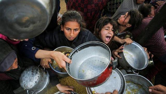 Gazians esperen rebre menjar d'una ONG a Khan Yunis, al sud de la Franja de Gaza (Hatem Khaled / Reuters)