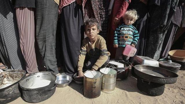 Dos nens esperen en una cua per rebre menjar en un camp de refugiats a Deir al-Balah, a la Franja de Gaza