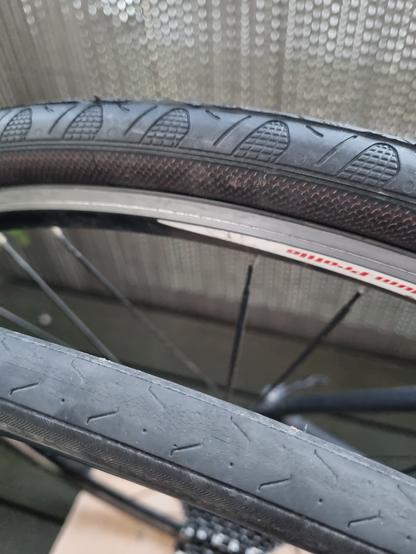 Vorne der alte Rennradreifen mit Rissen auf der Lauffläche, hinten der nagelneue.