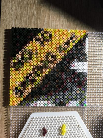 A close-up of one of the pegboards with a lot of beads on it.