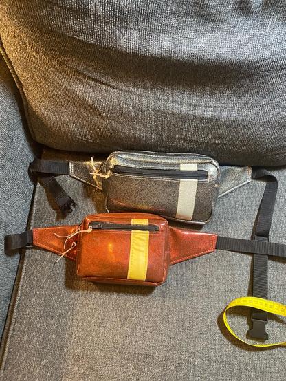 Two sizes of belt bag I made, ruby red sparkle with glow in the dark stripe is 6.5”x5”x2”, charcoal sparkle with silver white sparkle stripe is 8.5”x5”x2”