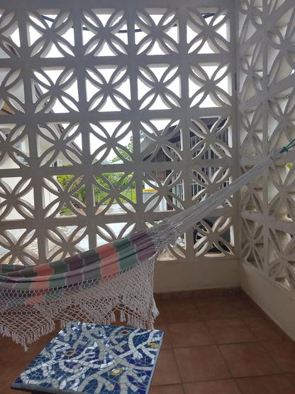 Un hamac dans la verrière d'une maison créole à Cayenne