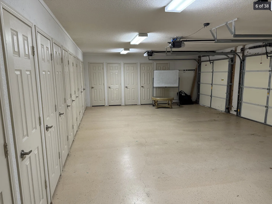 A garage with a ton of doors all side by side, there are at least a dozen.