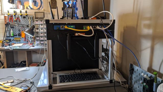 network rack in a messy room full of electronics and computer stuff