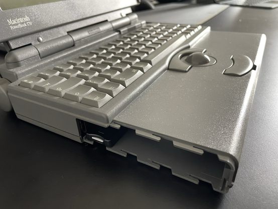 The PowerBook 170 reassembled, showing the microSD socket accessible from the side of the battery door. No battery is inserted.
