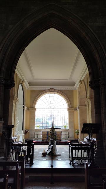 Looking to the east window of a church, but it is a huge glazed arched window of the style found in Georgian country houses with no stone mullions dividing it up as is usually found in church windows