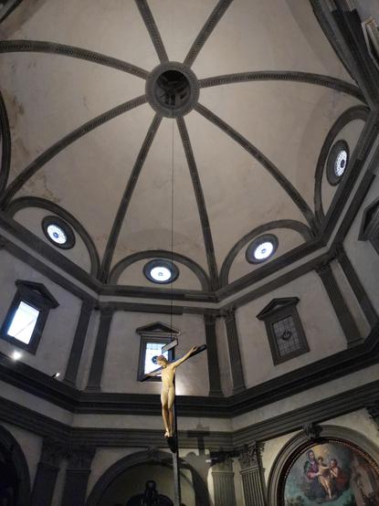 Coupole de la sacristie: des lignes de pierre grise (pietra serena) marquent les arêtes des volumes : coupole et tambour à 8 pans, tympans, arches.
Au centre est suspendu un crucifix sur lequel le christ est nu.