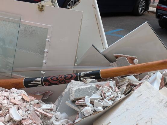 A didgeridoo amidst the rubble of a building.