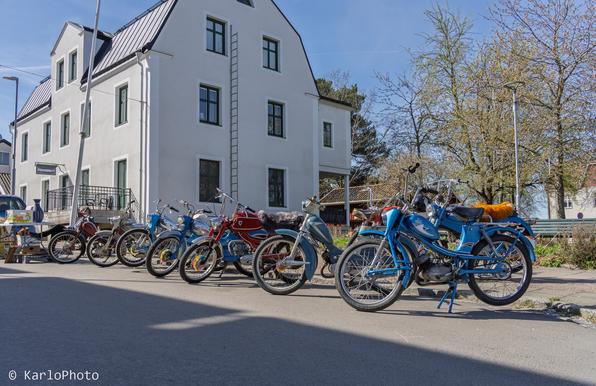Old mopeds lined up along the street