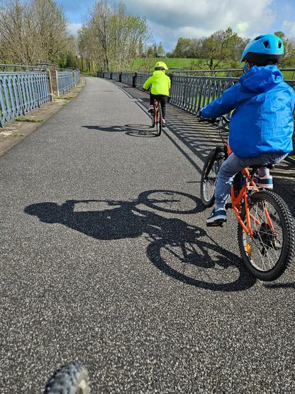 Numéro 1 et 2 sur leurs vélos passant sur un pont sur la piste verte