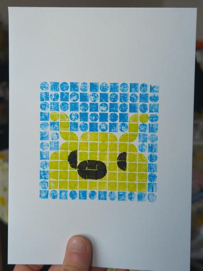 impression à l'huile avec des lego, d'une limace verte avec des yeux et un nez, sur un fond bleu