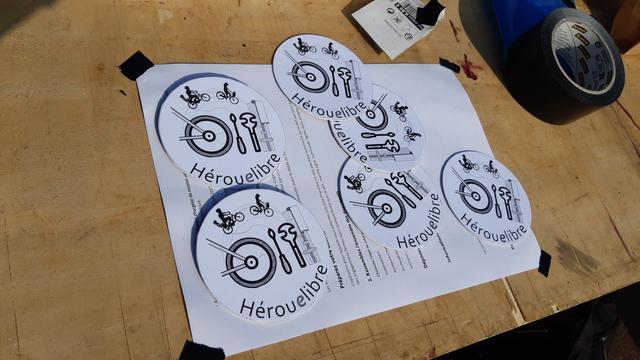 Fabrication de nouveaux badges "Hérouelibre" sur une table en bois pliante