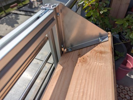Closeup of one planter cup angle. Attachment of the angle to the profile and the wood via screws are visible.