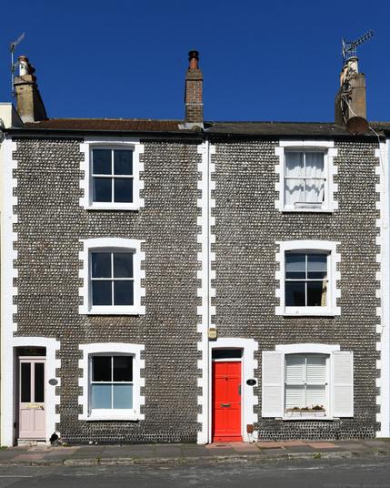 Photo of a pair of cottages of early C19, with coursed beach-cobble facades and painted-brick quoining. Within the Queen's Park Conservation Area, City of Brighton & Hove, UK.