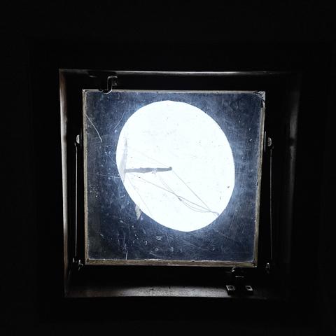 looking up through a window, through another plasic window of a canvas cover, at the mast of a sailboat.