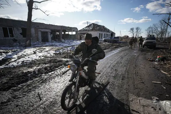 A Russian soldier rides a motorbike past destroyed buildings in the village of Kazachya Loknya in the Sudzha district of Kursk Oblast, March 2025