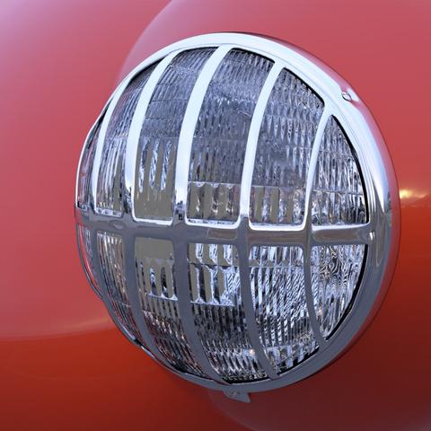 A 3D rendered closeup of a circular car headlight partly covered by a chrome grille, with the red body of the car partially visible behind.