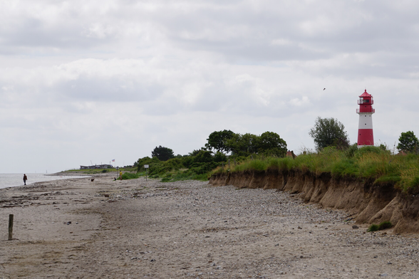 Blick vom Strand aus, mit Leuchtturm im Hintergrund