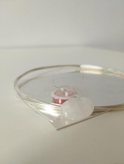 silver wire, copper wire, a silver plate and an oval pink gemstone